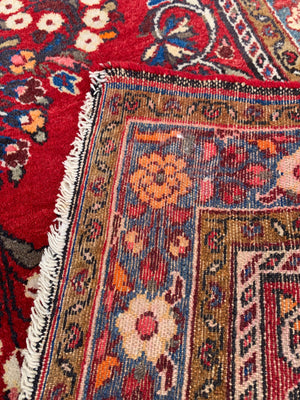 A red ground woolen Persian rug ~ 180cm x 110cm