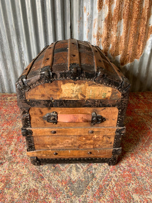 An oak dome top steamer trunk with tooled leather motifs