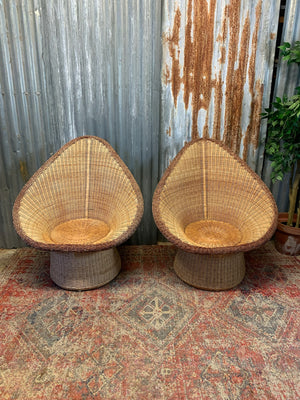 A pair of wicker egg chairs