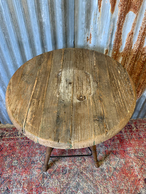 A sculptor's stand with circular oak top