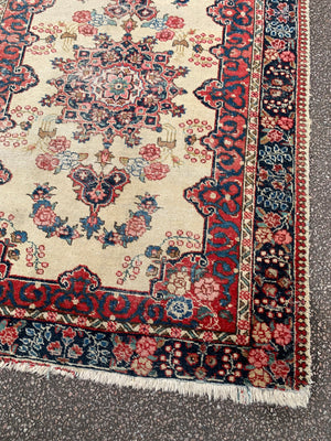 A Persian cream ground rug ~ 194cm x 133cm