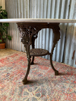 A cast iron Britannia garden table with marble top