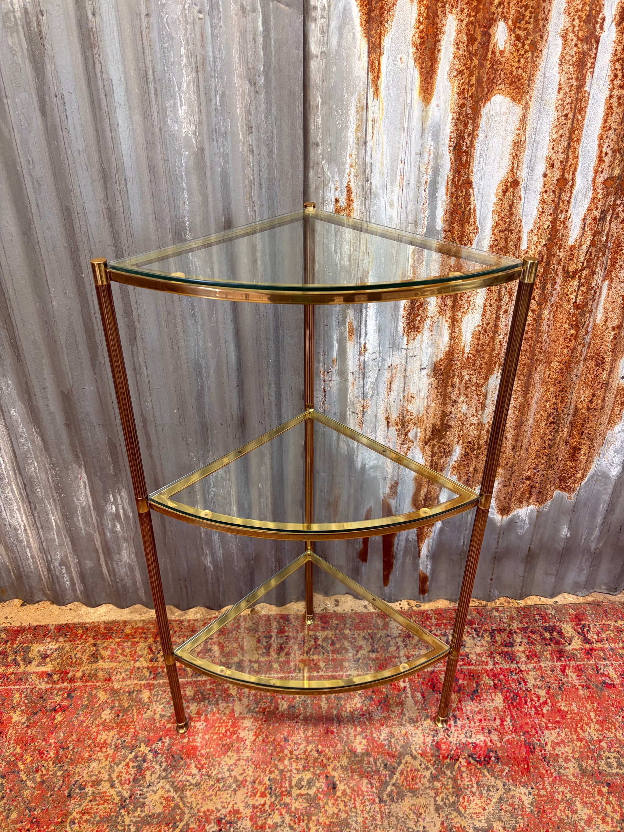A three tier Hollywood Regency corner display stand