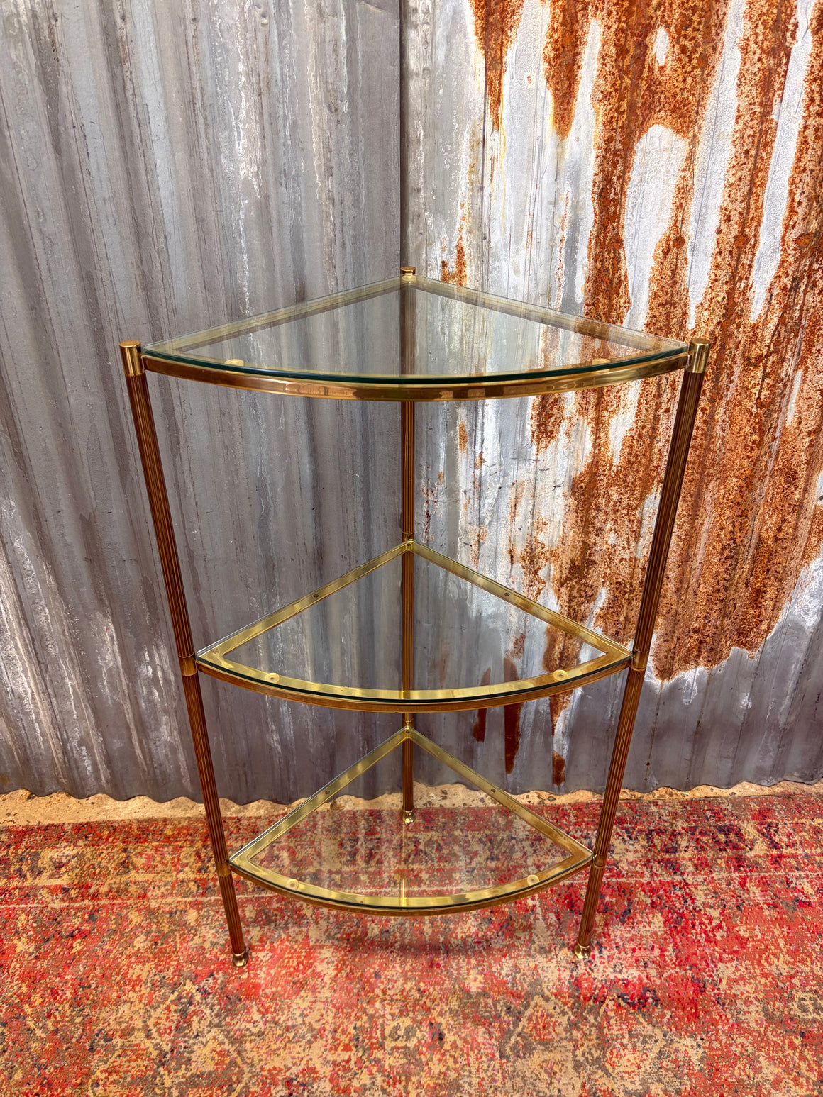 A three tier Hollywood Regency corner display stand