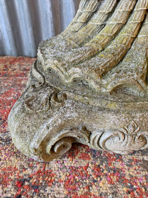 A cast stone bird bath in the form of a shell