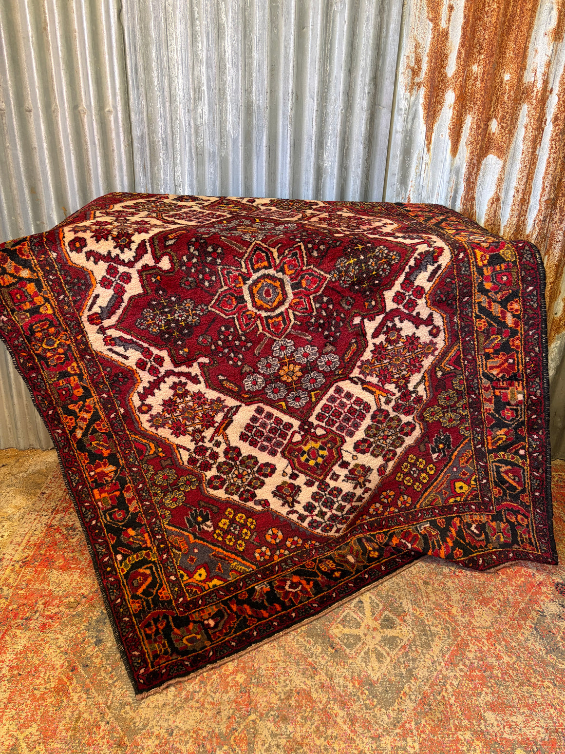A red ground patterned rug ~ 203cm x 135cm