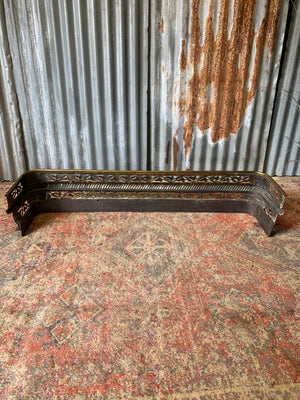 A large Victorian brass fender with lion paw feet
