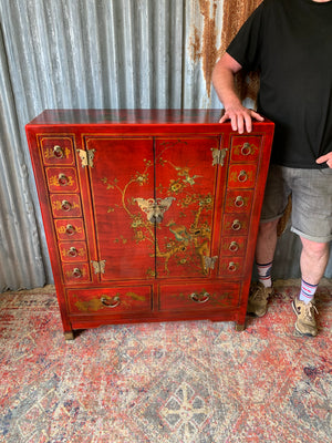 A red and gold lacquered chinoiserie cabinet