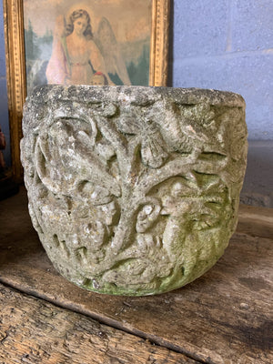 A pair of large cast stone urns with flora and fauna detailing