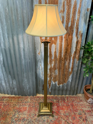 A brass Corinthian column standard lamp on lion paw feet