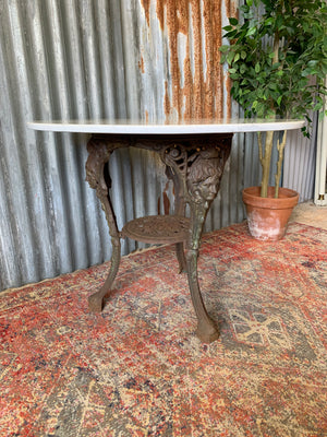 A cast iron Britannia garden table with marble top