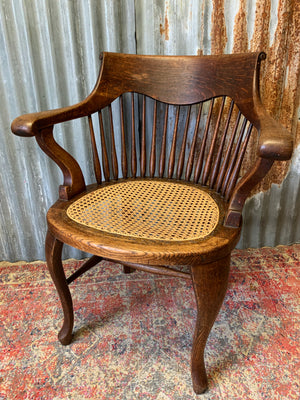 A banker's chair with caned seat