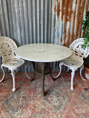 A cast iron Britannia garden table with marble top