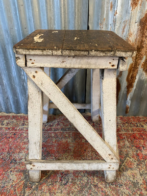 A wooden square-topped sculpture stand