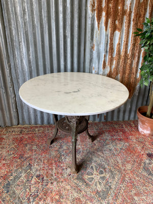 A cast iron Britannia garden table with marble top