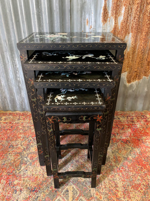 A nest of four black lacquered chinoiserie tables