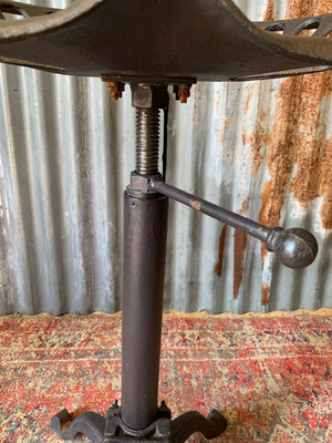 A cast iron adjustable tractor seat stool