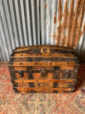 An oak dome top steamer trunk with tooled leather motifs