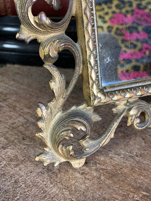 An ornate brass Rococo styled easel back mirror