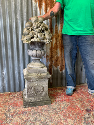 A cast stone cornucopia on plinth