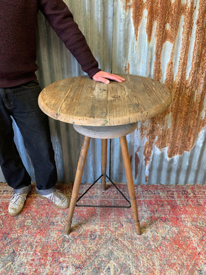 A sculptor's stand with circular oak top