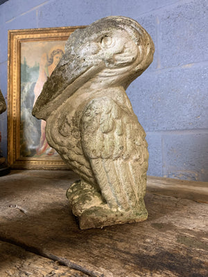 A trio of cast stone pelican statues