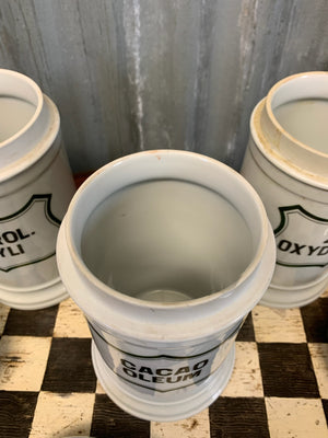 A set of three white ceramic apothecary jars