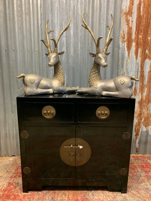 A pair of opposing white metal stags