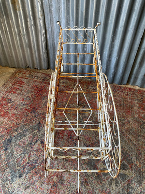 A pair of white wirework barrow plant stands