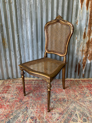 A rococo-style giltwood cane chair