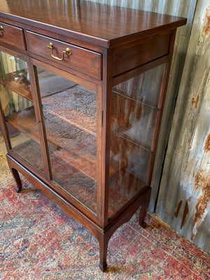 A mahogany double-fronted glass display cabinet with two drawers