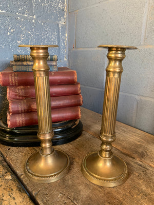 A pair of Neoclassical brass candlesticks