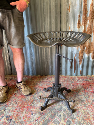 A cast iron adjustable tractor seat stool