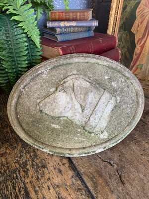 An oval cast stone plaque depicting a dog's head in profile ~B