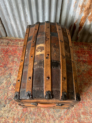 An oak dome top steamer trunk with tooled leather motifs