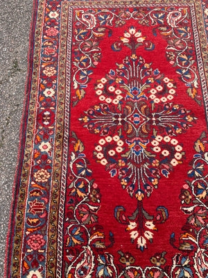 A red ground woolen Persian rug ~ 180cm x 110cm