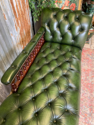 A Victorian-style green leather chaise longue