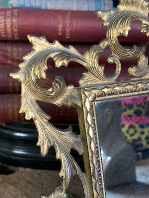 An ornate brass Rococo styled easel back mirror