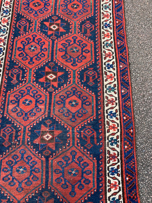 A long red ground blue Persian runner rug ~ 304cm x 104cm