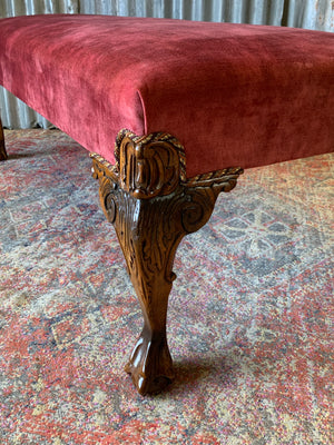 A large red velvet ball and claw footstool