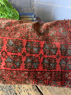 A Persian red ground rectangular carpet cushion - 109cm x 52cm