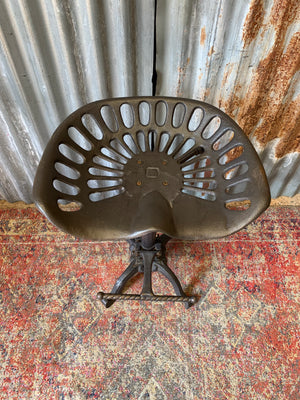 A cast iron adjustable tractor seat stool