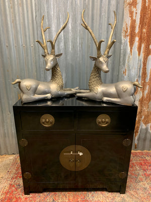 A pair of opposing white metal stags