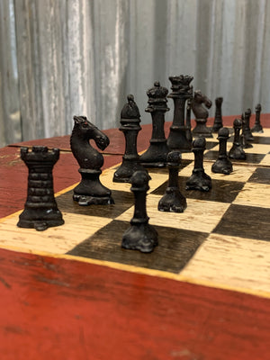 A cast iron bistro table with hand-painted chess board top