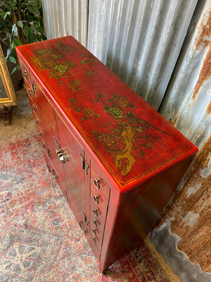 A red and gold lacquered chinoiserie cabinet