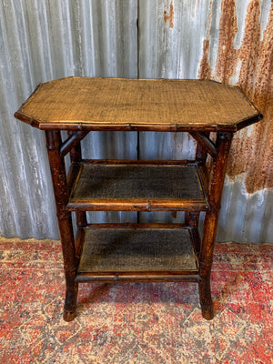 A three tier bamboo occasional table with rattan top