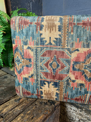 A large kilim-style footstool on cabriole legs