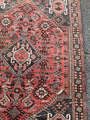 A Persian red ground rectangular rug- 161cm x 117cm