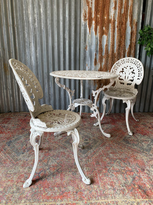 A white garden table and two chairs set