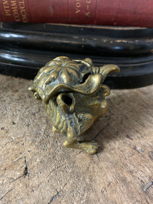 A brass inkwell in the form of an imp